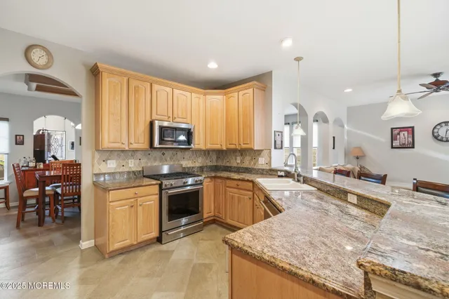 a kitchen with stainless steel appliances granite countertop sink stove top oven and cabinets