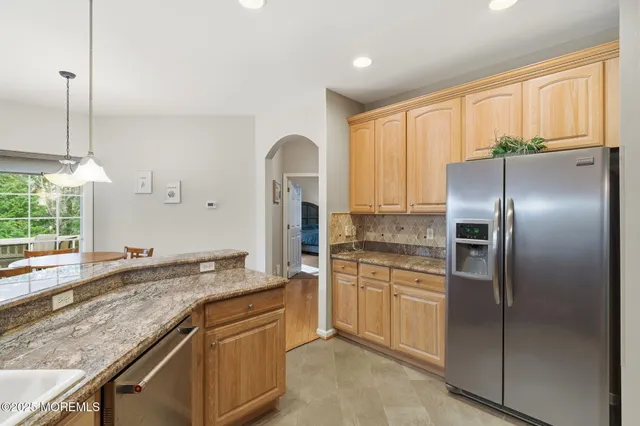 a kitchen with granite countertop stainless steel appliances a refrigerator sink and microwave