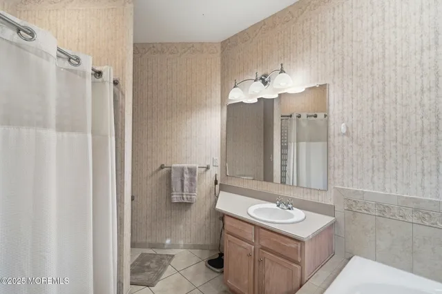 a bathroom with a bath tub sink and mirror