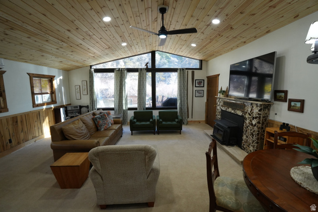 3711 North Canyon Road Provo, UT 84604 - Photo 23 of 42 Carpeted living area with a wainscoted wall, wooden walls, vaulted ceiling, wood ceiling, and a wood stove