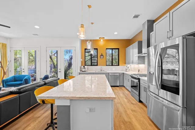 a kitchen with stainless steel appliances granite countertop a sink a stove and refrigerator