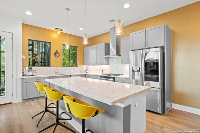 a kitchen with a table chairs refrigerator and cabinets
