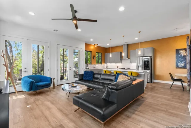 a living room with furniture kitchen view and a large window