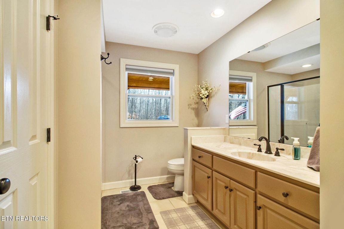 1375 Back Bone Road Sparta, TN 38583 - Photo 32 of 52 a spacious bathroom with a granite countertop sink a toilet a mirror and shower