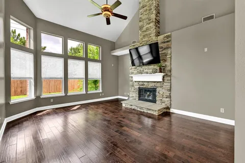 a view of empty room with fireplace and wooden floor