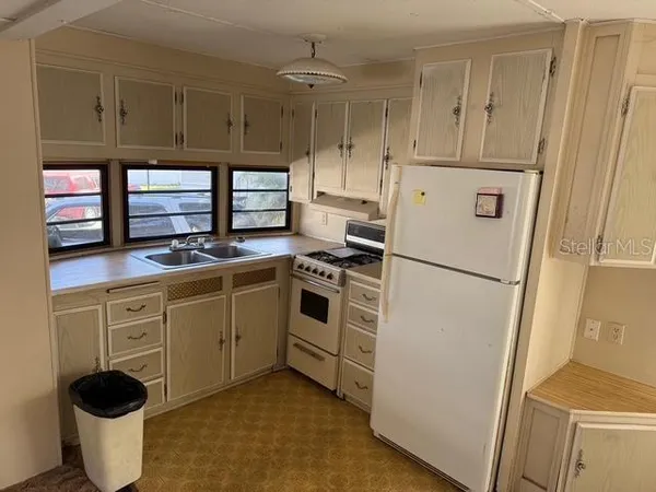 a kitchen with stainless steel appliances a refrigerator sink and cabinets