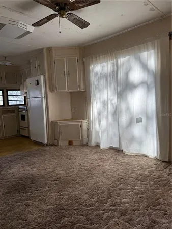 a view of a refrigerator in kitchen and a glass window