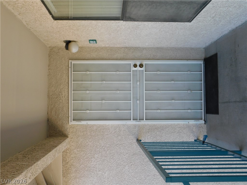 5221 South Lindell Road, Unit 202 Las Vegas, NV 89118 - Photo 5 of 28 A window with security bars on a textured stucco wall, ensuring both light and peace of mind.