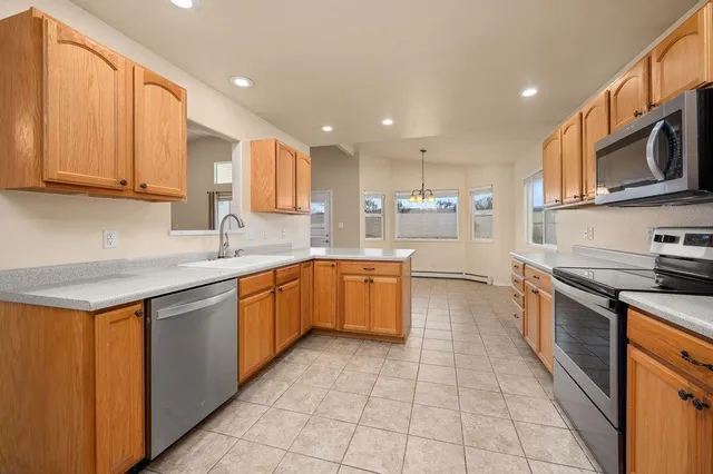 a kitchen with stainless steel appliances granite countertop a stove top oven a sink dishwasher and a microwave oven on the blue kitchen countertops