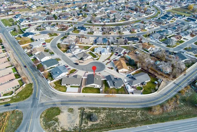 an aerial view of house with yard and mountain view in back