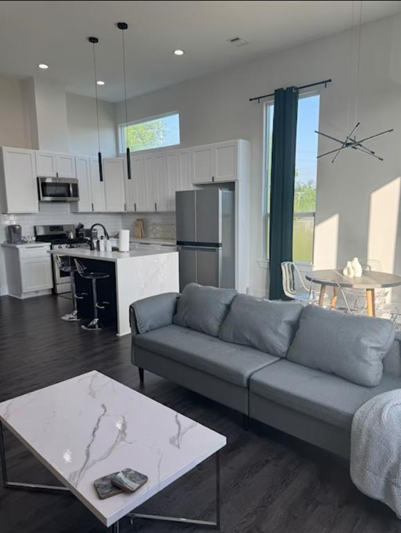 3610 Dreyfus Street, Unit A Houston, TX 77021 - Photo 5 of 20 a living room with stainless steel appliances kitchen island granite countertop a couch a stove a dining table and chairs with wooden floor