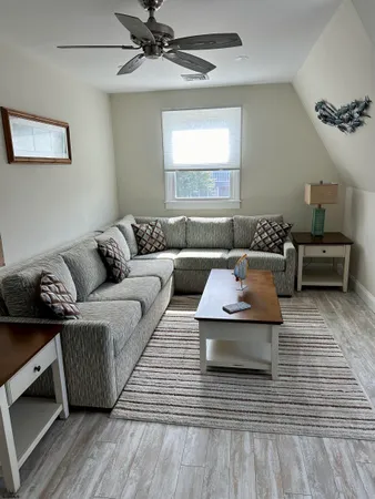 a living room with furniture and a wooden floor