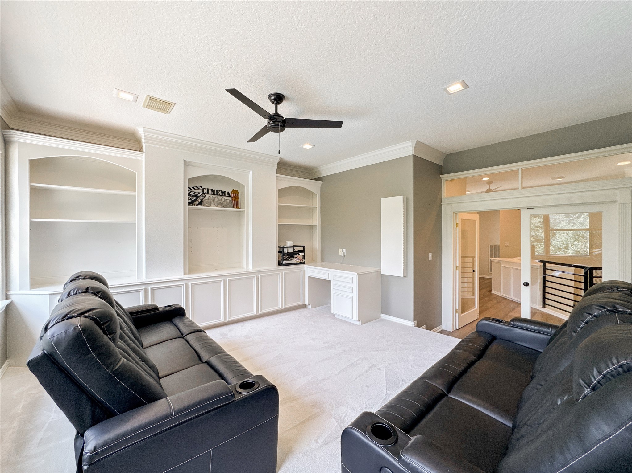 1810 Woerner Road Houston, TX 77090 - Photo 26 of 39 Upstairs media room with plush seating, built-in shelving, and ample natural light—perfect for entertainment.