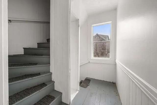 a view of bedroom and hallway with wooden floor