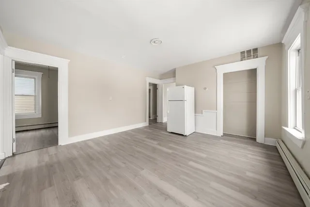 a view of empty room with wooden floor and fireplace