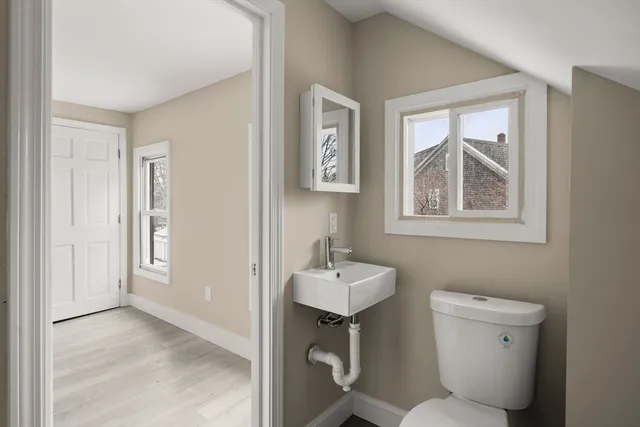 a bathroom with a toilet sink and mirror