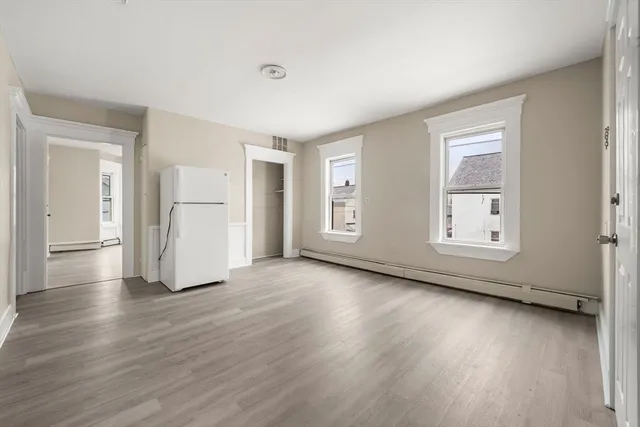 a view of empty room with wooden floor and window