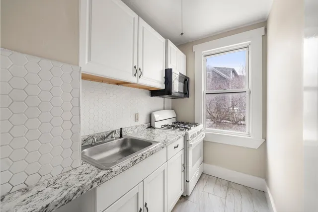 a kitchen with stainless steel appliances granite countertop a sink stove and window