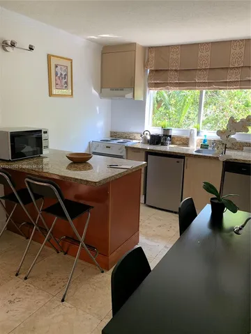 a kitchen with a sink a stove and a microwave