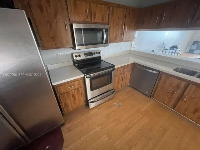 a kitchen with wooden cabinets and stainless steel appliances