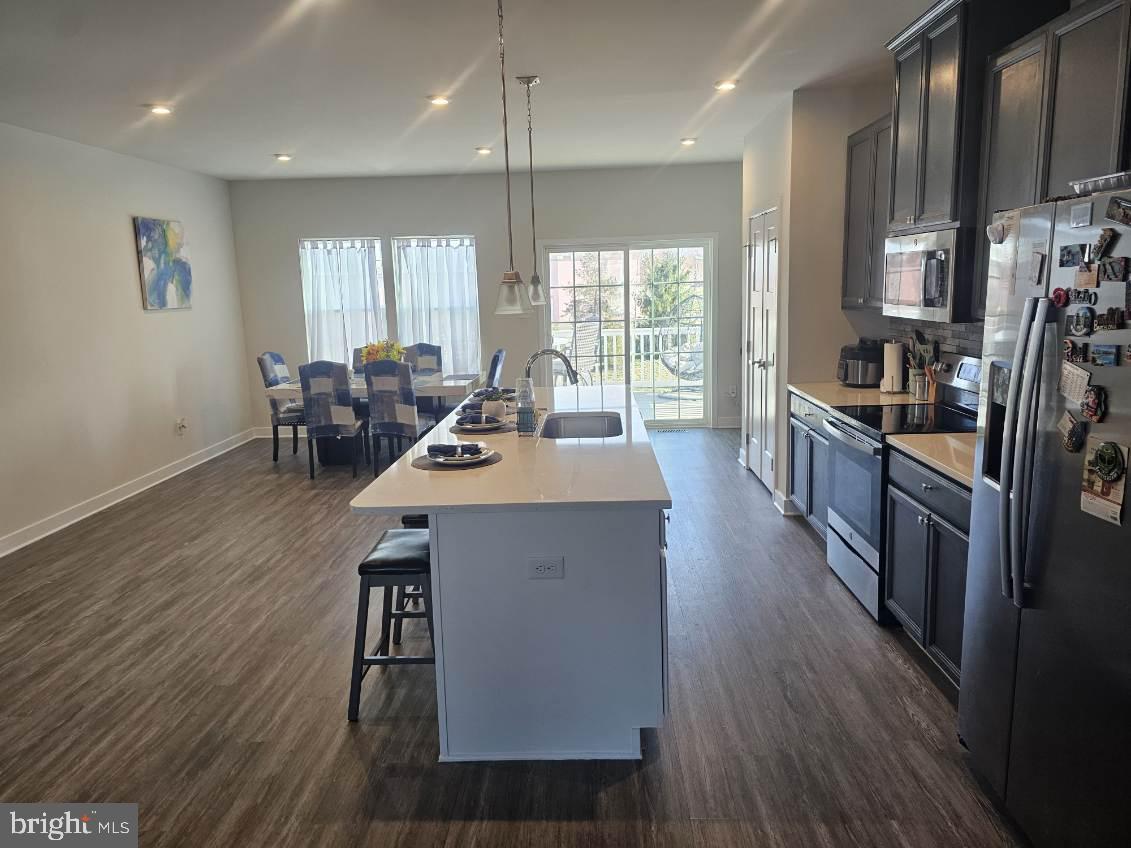 108 Freedom Way Sicklerville, NJ 08081 - Photo 2 of 9 a kitchen with stainless steel appliances a dining table chairs stove refrigerator and cabinets