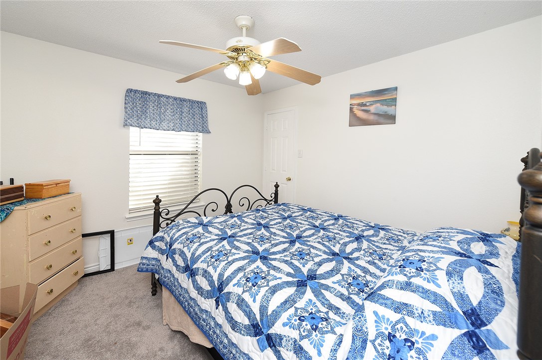 2101 Capeheart Street Ingleside, TX 78362 - Photo 23 of 39 a bedroom with a bed and a chandelier