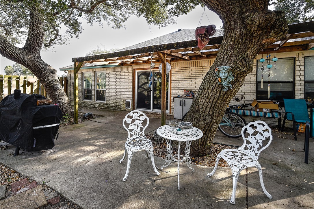 2101 Capeheart Street Ingleside, TX 78362 - Photo 30 of 39 a view of a patio with table and chairs potted plants and a large tree