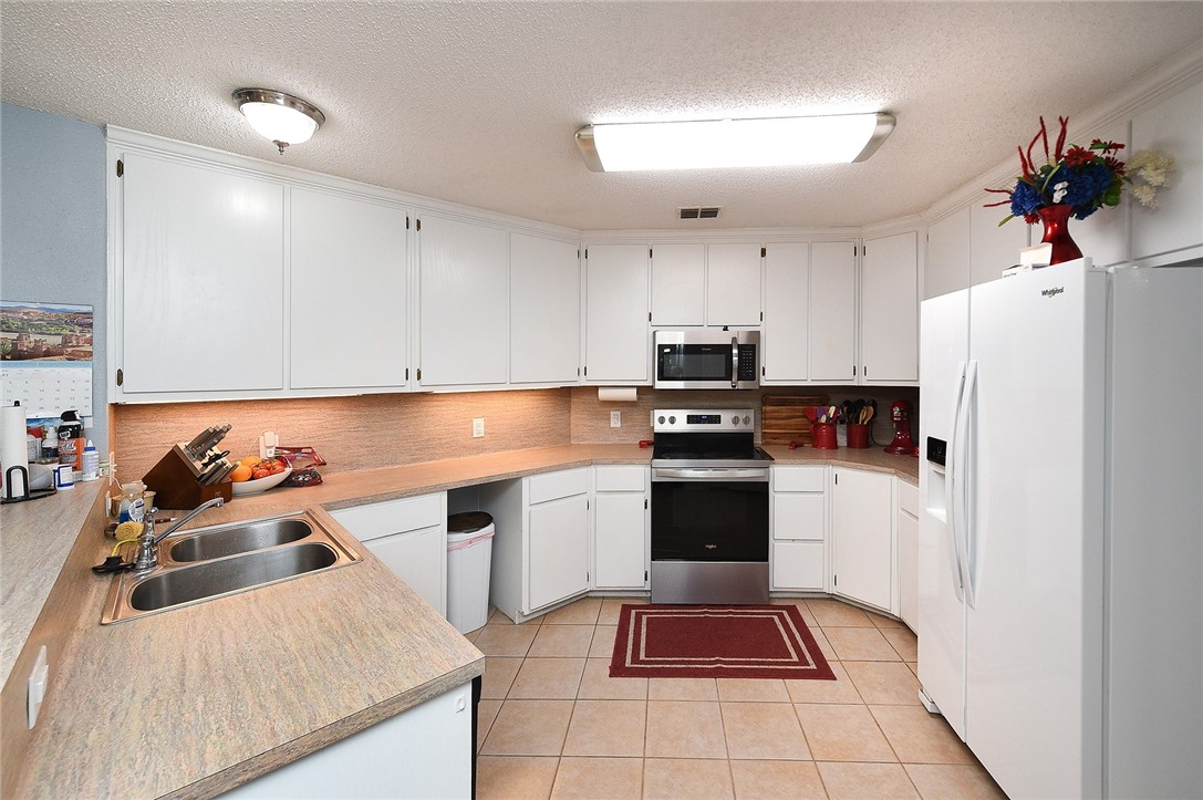 2101 Capeheart Street Ingleside, TX 78362 - Photo 9 of 39 a kitchen with a refrigerator and white cabinets