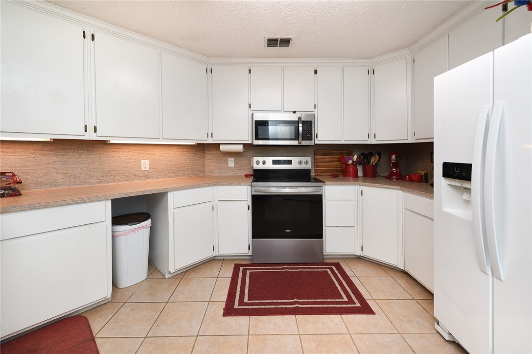 2101 Capeheart Street Ingleside, TX 78362 - Photo 10 of 39 a kitchen with white cabinets and white appliances