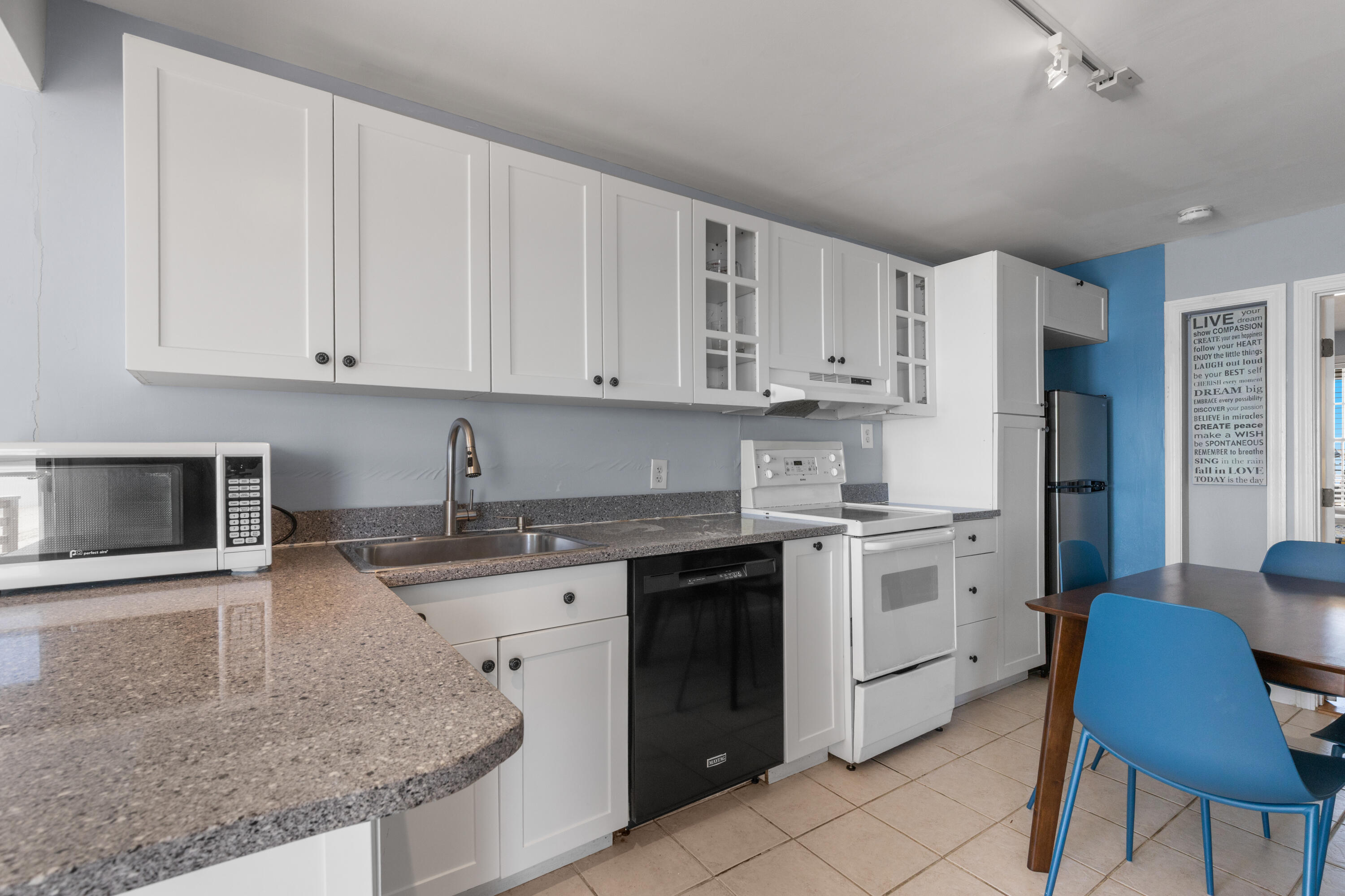 538 Shore Road, Unit 3 Truro, MA 02666 - Photo 7 of 27 a white kitchen with granite countertop a stove a sink a refrigerator and white cabinets