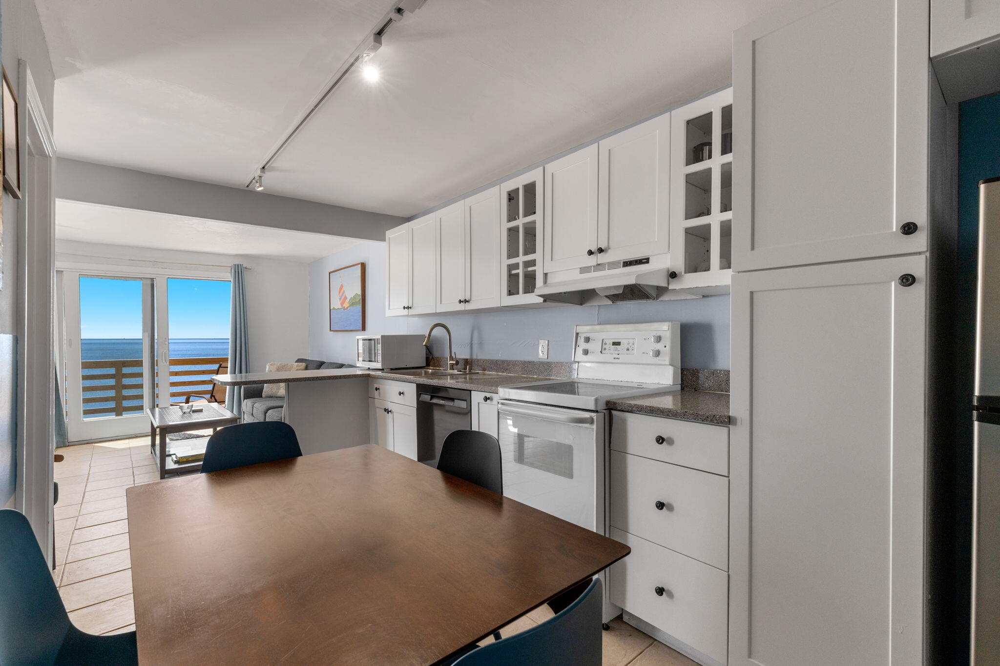 538 Shore Road, Unit 3 Truro, MA 02666 - Photo 9 of 27 a kitchen with stainless steel appliances white cabinets a sink a stove a refrigerator and white cabinets