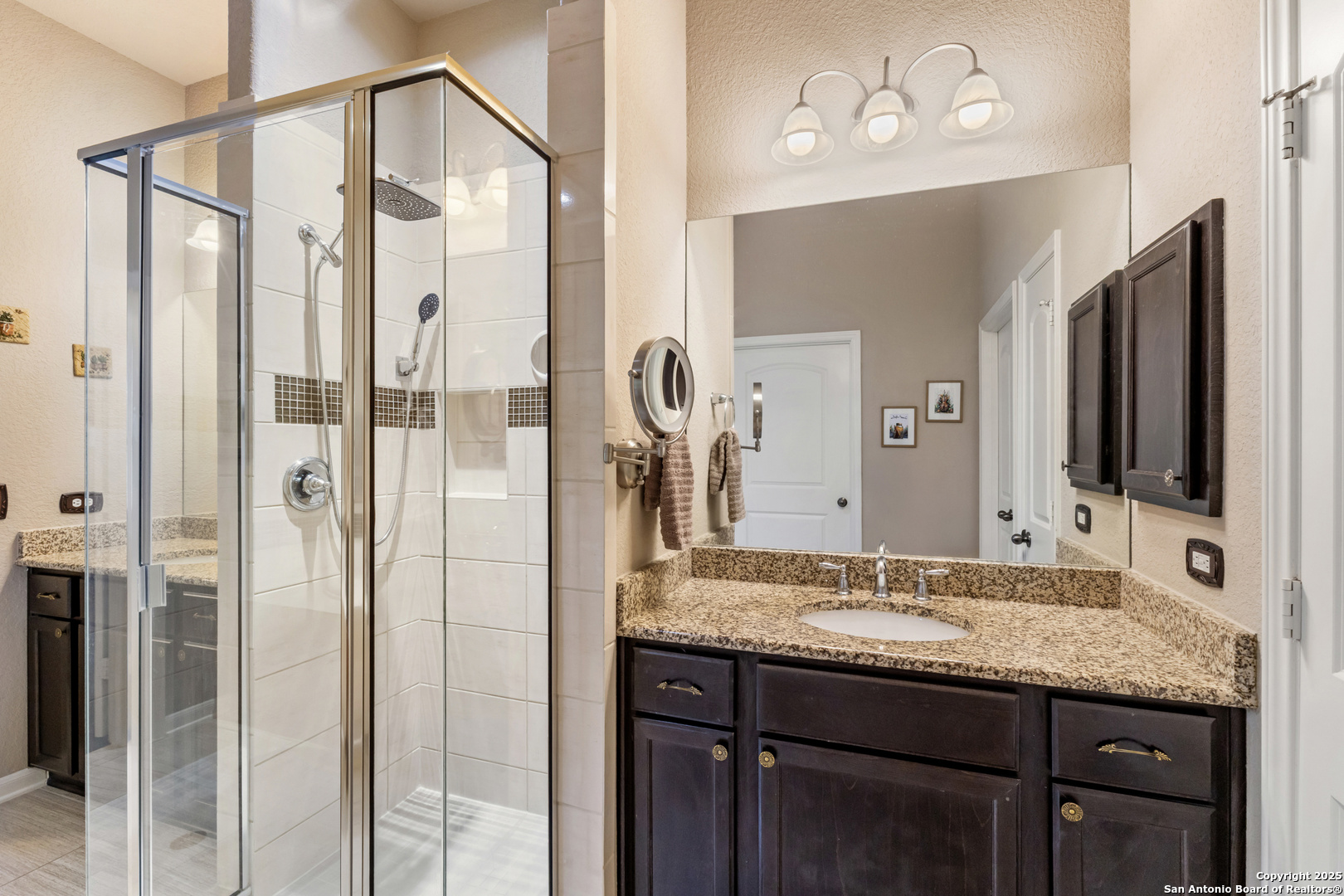 123 Gaucho Boerne, TX 78006 - Photo 14 of 26 a bathroom with a granite countertop sink a mirror and shower