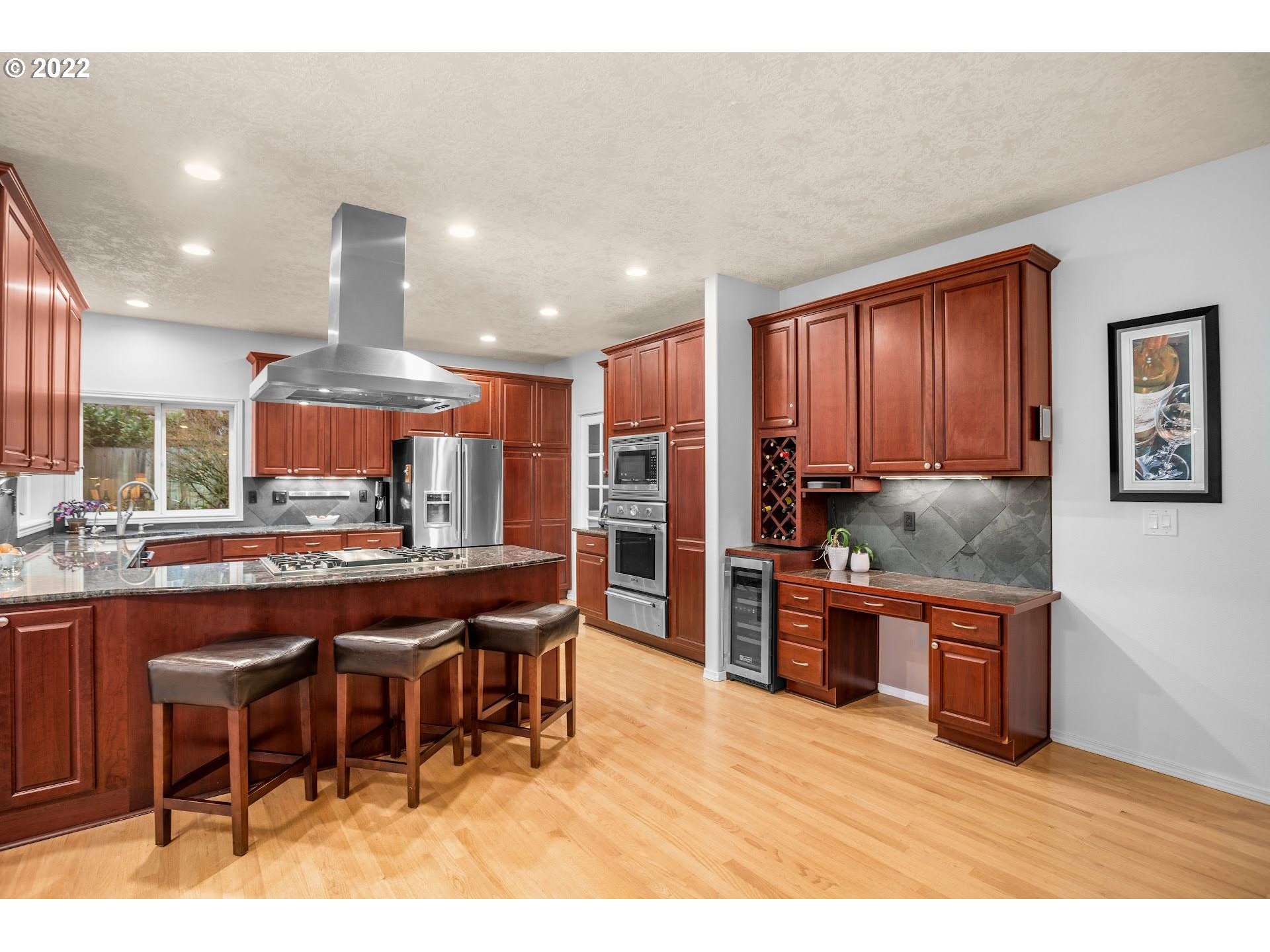 16625 Southwest Springwater Court Beaverton, OR 97006 - Photo 13 of 32 a kitchen with stainless steel appliances granite countertop a table chairs sink and refrigerator