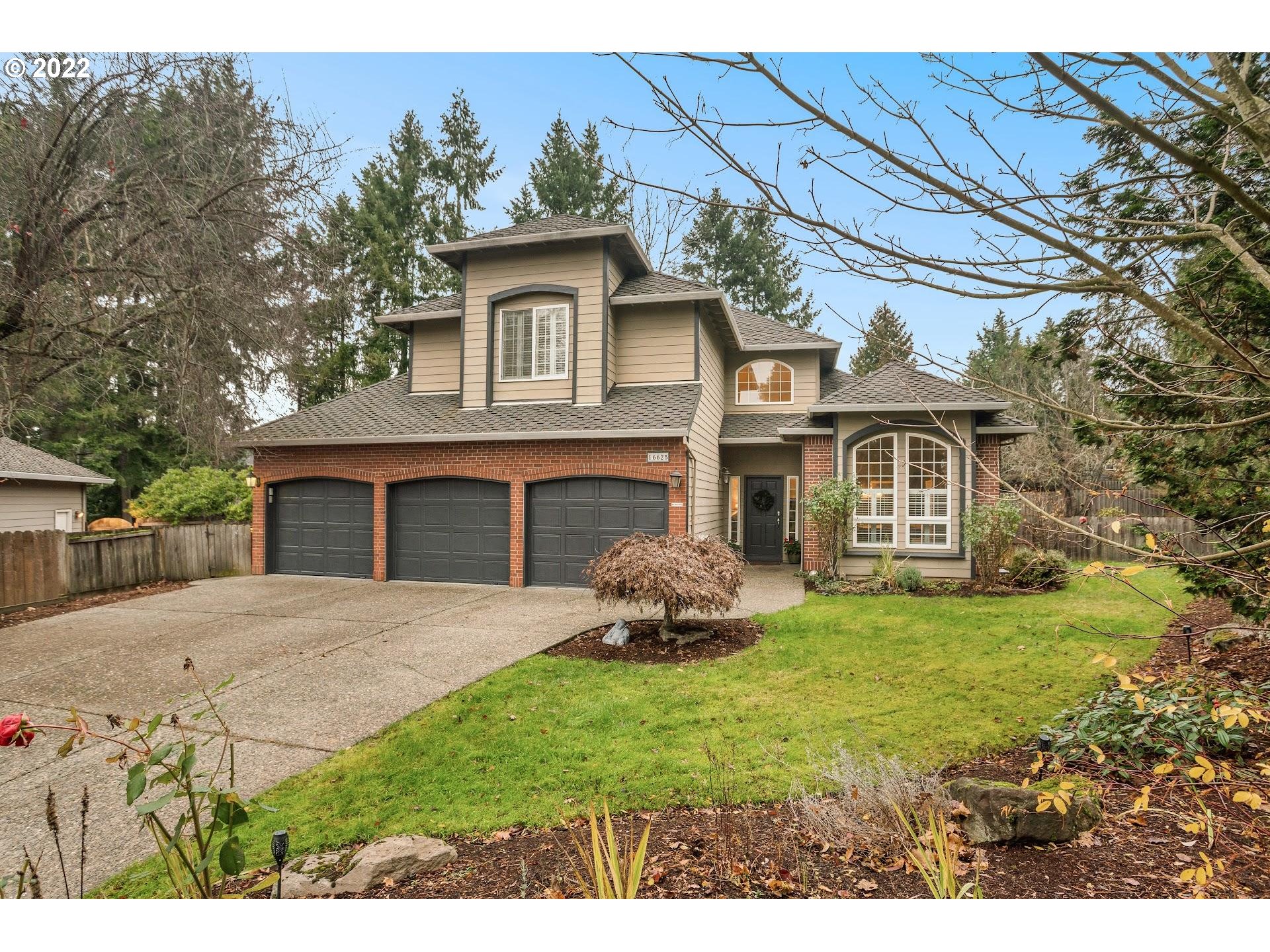 16625 Southwest Springwater Court Beaverton, OR 97006 - Photo 2 of 32 a front view of a house with a garden and yard