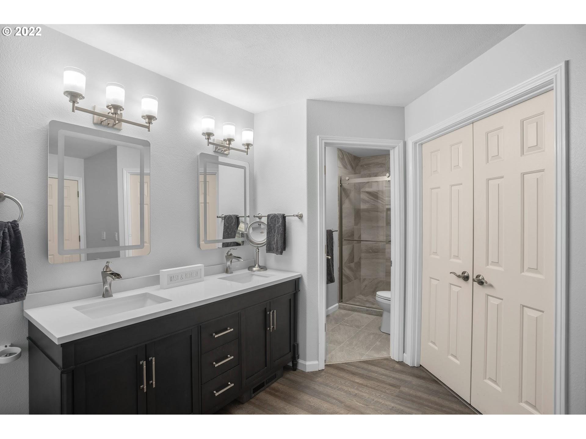16625 Southwest Springwater Court Beaverton, OR 97006 - Photo 21 of 32 a bathroom with a sink vanity granite and a mirror