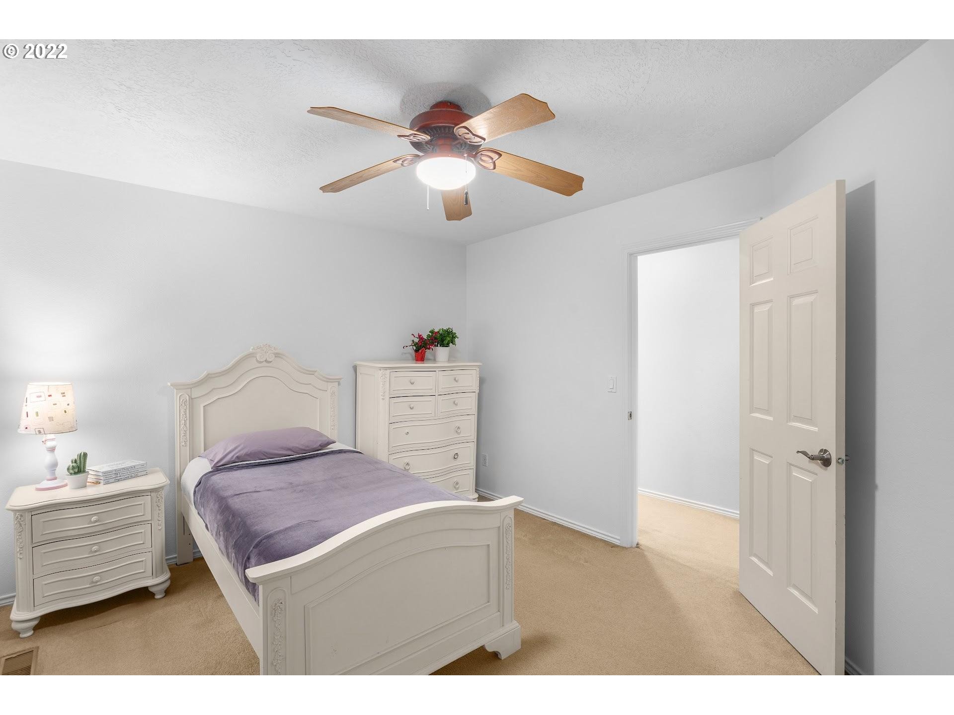 16625 Southwest Springwater Court Beaverton, OR 97006 - Photo 24 of 32 a bedroom with a bed and a chandelier
