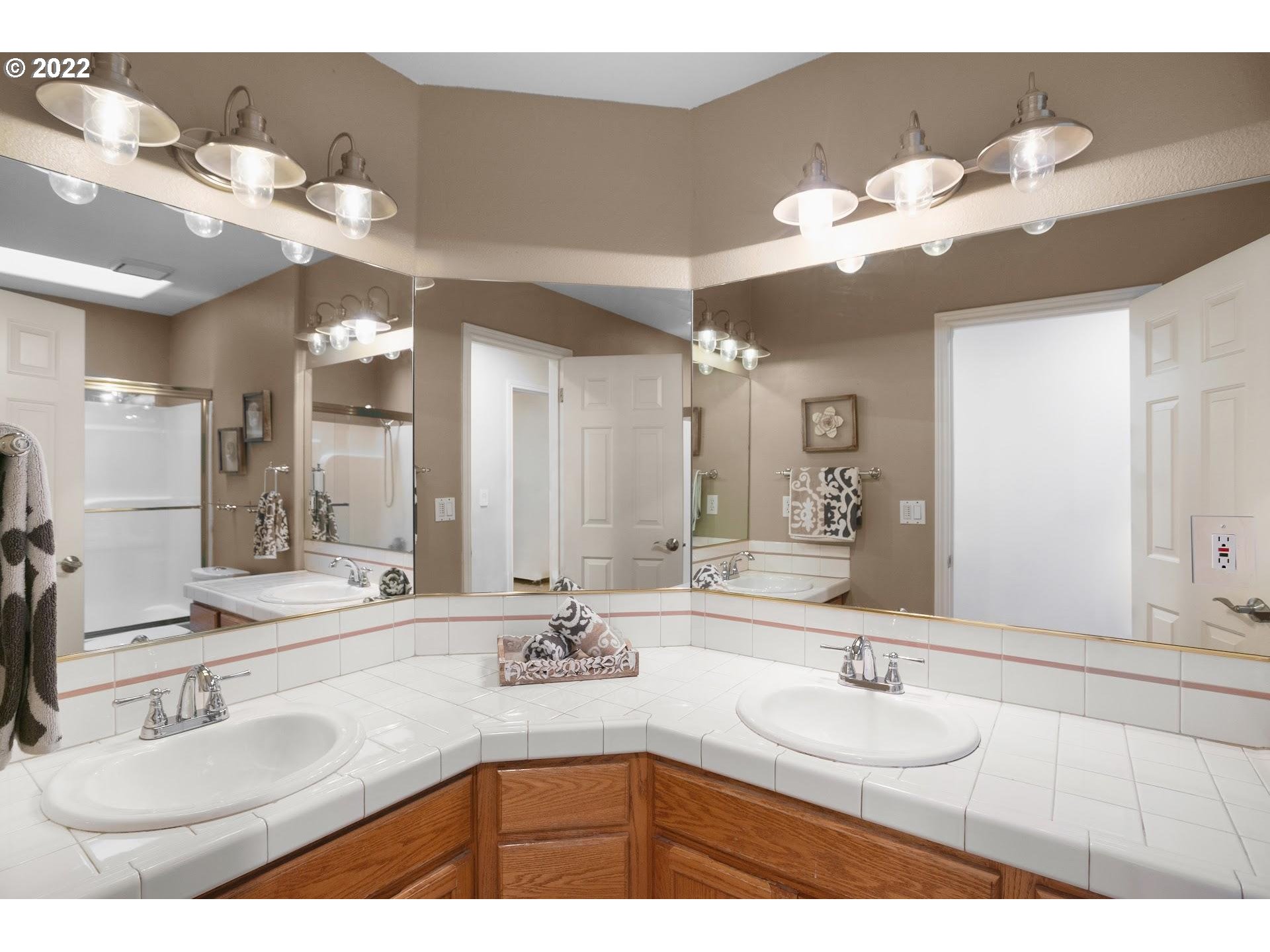 16625 Southwest Springwater Court Beaverton, OR 97006 - Photo 26 of 32 a bathroom with a sink vanity granite and a mirror