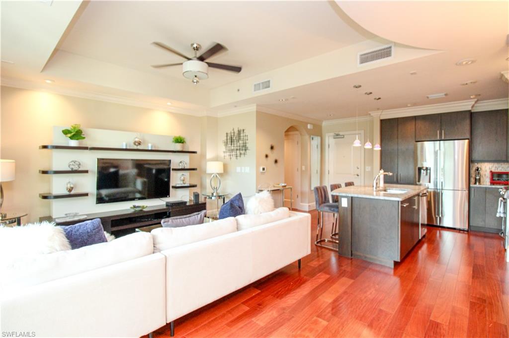 9123 Strada Place, Unit 7410 Naples, FL 34108 - Photo 32 of 50 Living room with hardwood / wood-style floors, ceiling fan, a raised ceiling, and sink