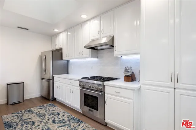 a kitchen with stainless steel appliances white cabinets and a stove