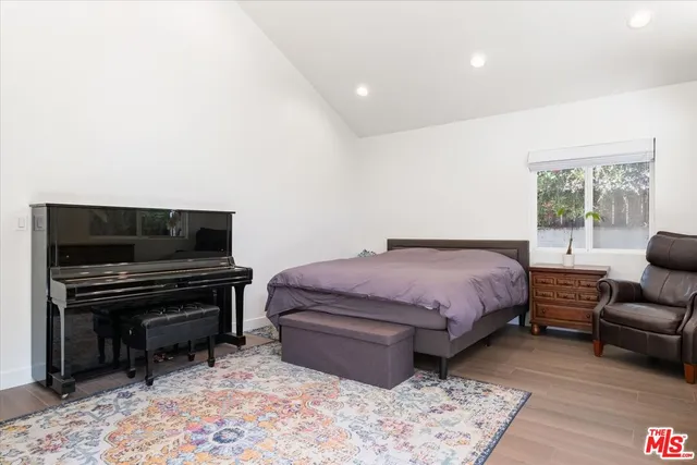 a spacious bedroom with a bed and a television