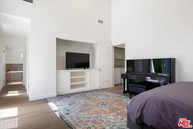a bedroom with a bed and a flat screen tv