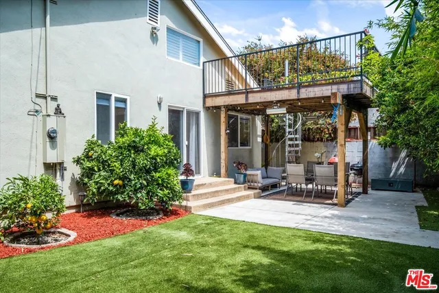 a view of a chair and table in backyard of the house
