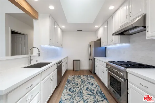 a kitchen with granite countertop a sink stove and cabinets