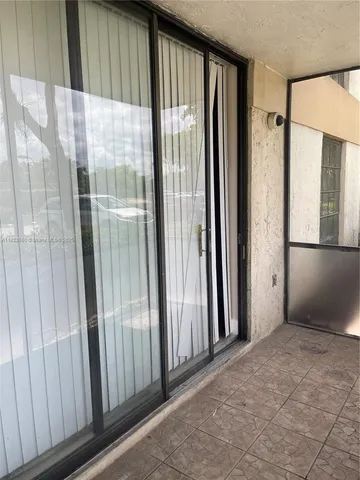 a view of a wooden chairs and table in the balcony