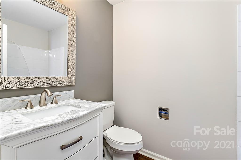 5011 Sharon Road, Unit E Charlotte, NC 28210 - Photo 14 of 19 a bathroom with a granite countertop toilet sink and mirror