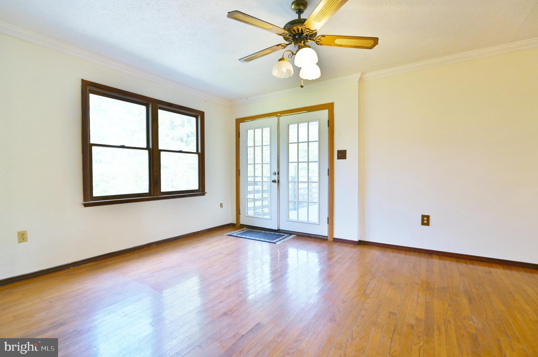 2784 Ridge Hollow Road Edinburg, VA 22824 - Photo 16 of 60 an empty room with wooden floor fan and windows