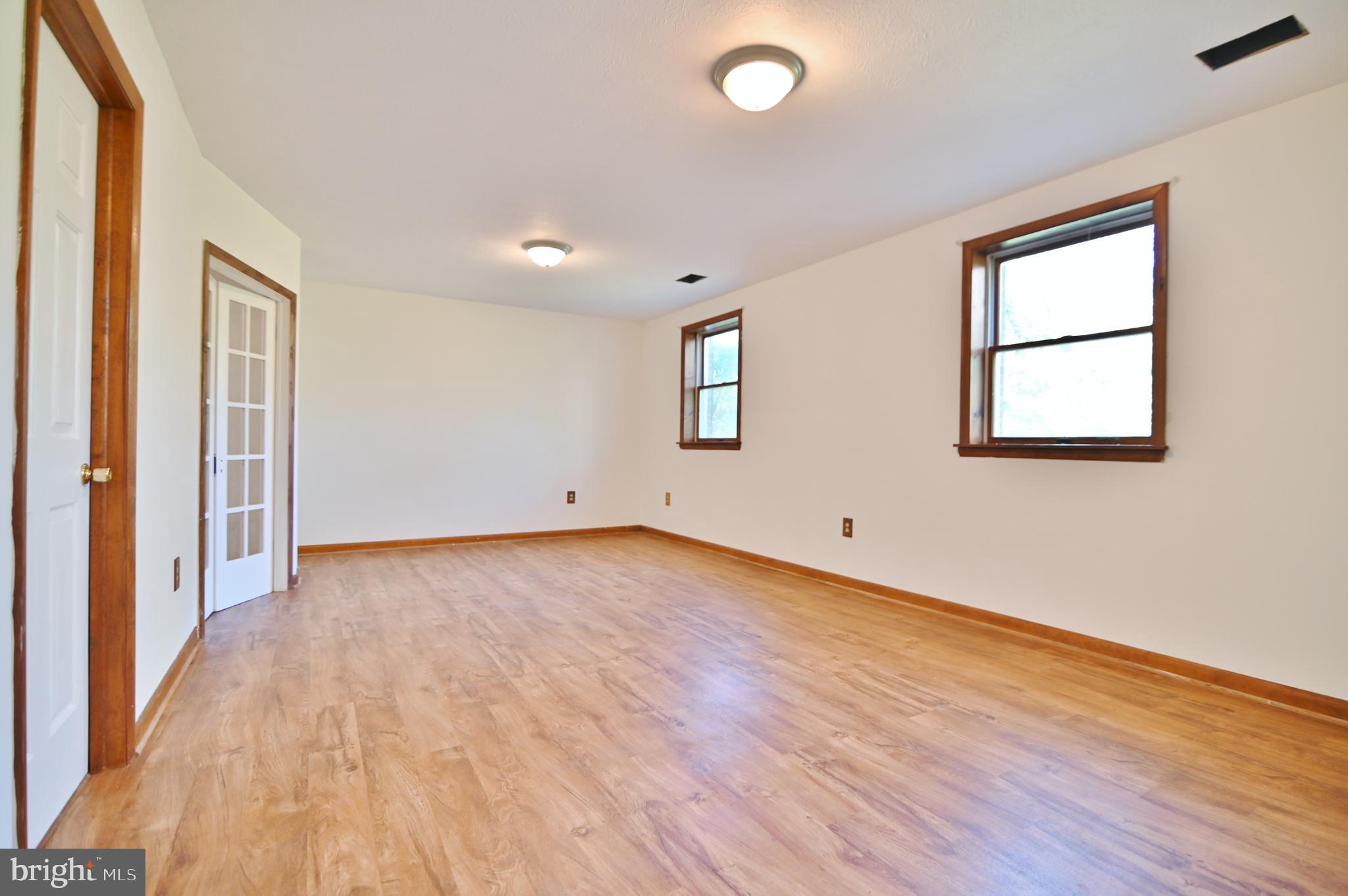 2784 Ridge Hollow Road Edinburg, VA 22824 - Photo 41 of 60 an empty room with wooden floor and windows