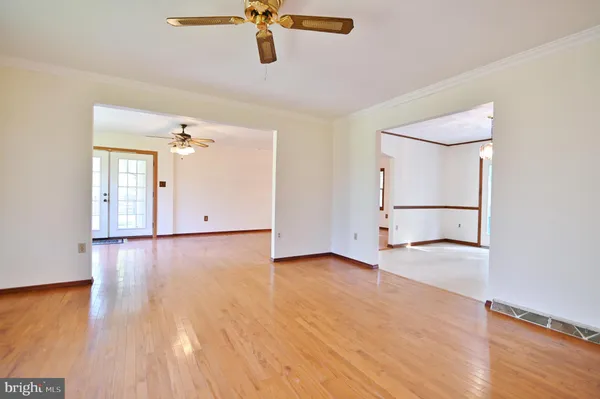 a view of an empty room with window and wooden floor
