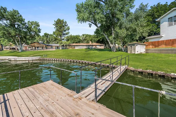a view of a wooden deck and a yard with swimming pool