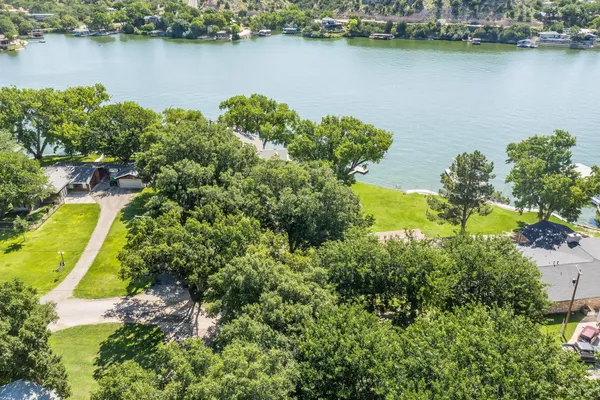 an aerial view of a residential houses with outdoor space and lake view